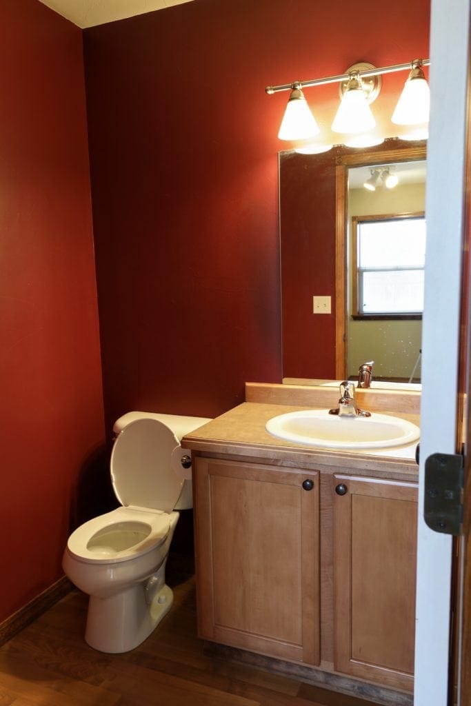 bathroom with red walls and basic vanity