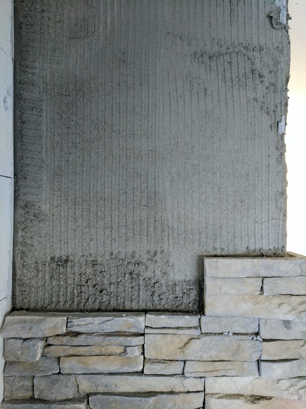 Installing stacked stone veneer on a fireplace