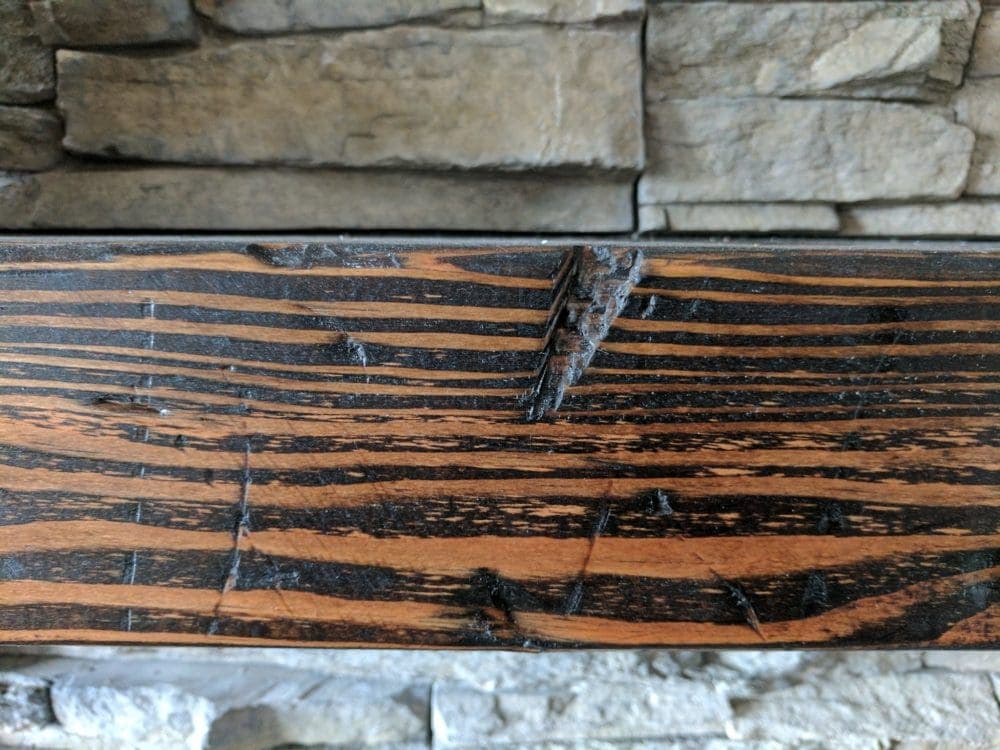 close up of a distressed wood beam mantle