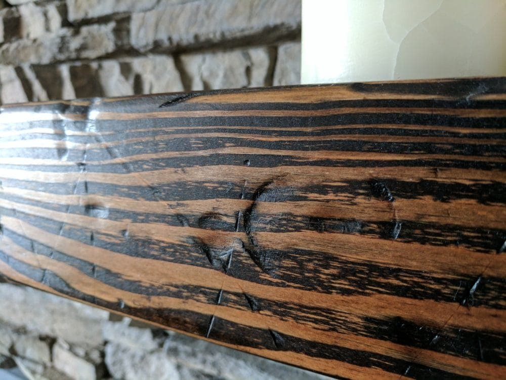 close up of a distressed wood beam mantle