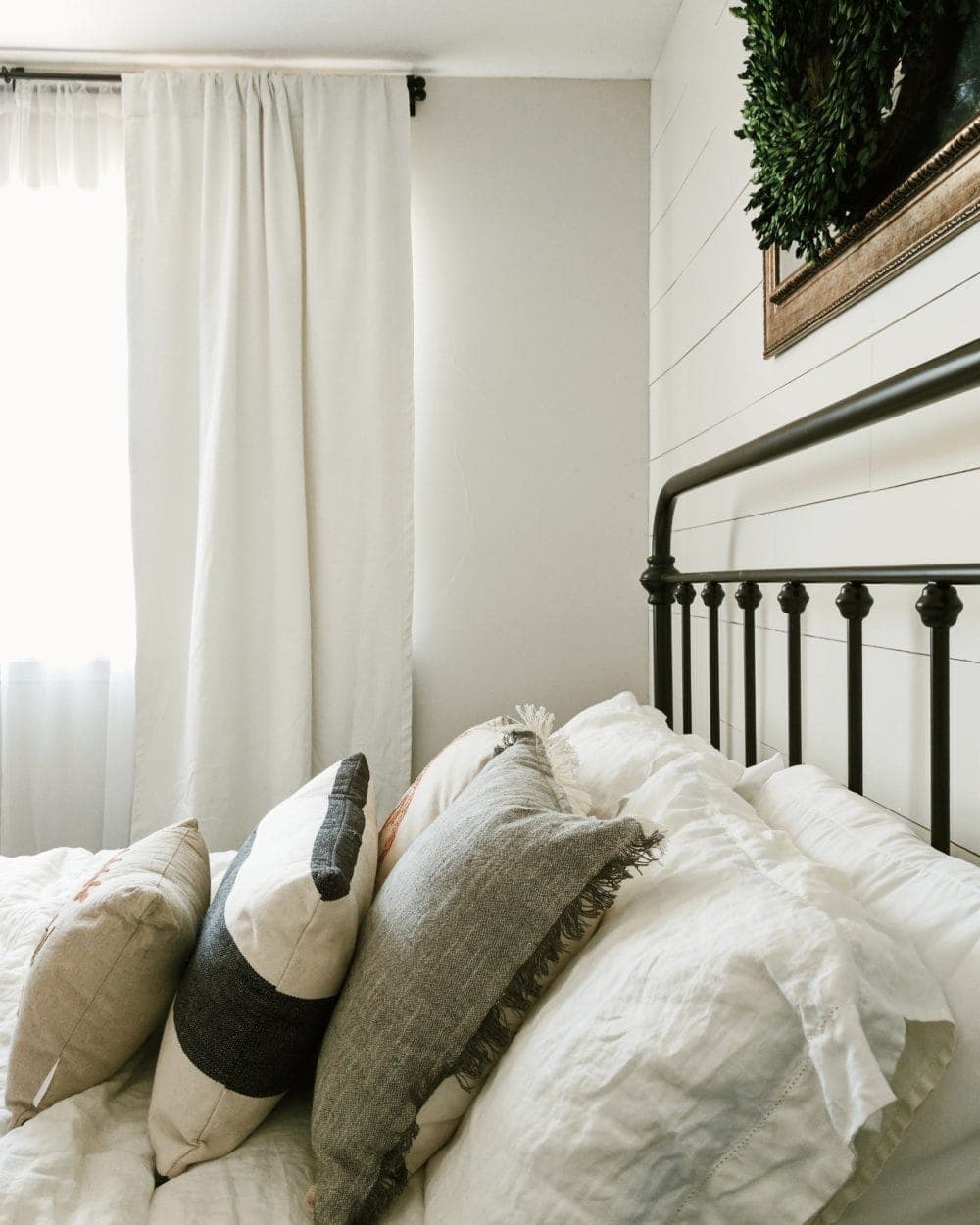 Farmhouse bedroom with white curtains and natural light