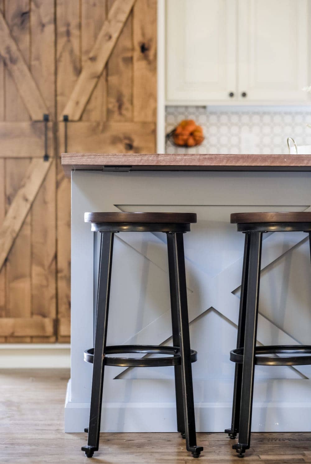 Rustic bar stools in front of a blue kitchen island