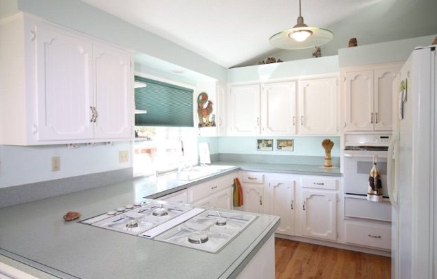 country kitchen on a budget with white cabinets and window over sink