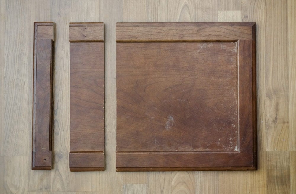 Cabinet door on ground with 2 cuts creating a middle piece to be removed