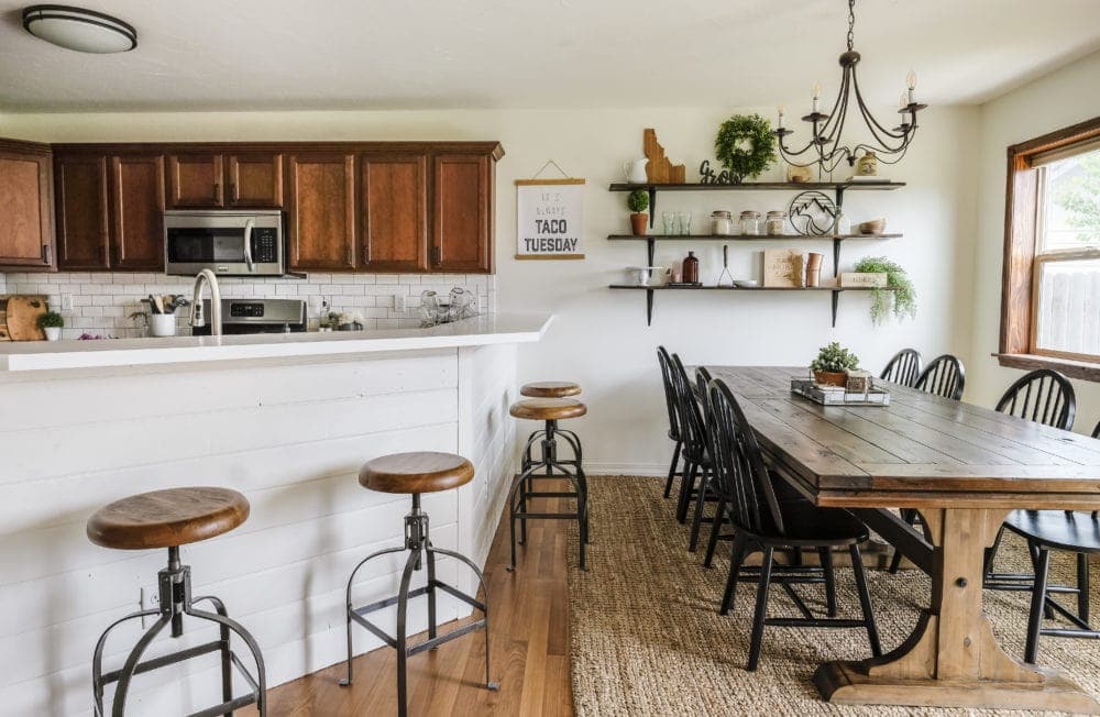 breakfast bar overlooking kitchen and long wood dining room table