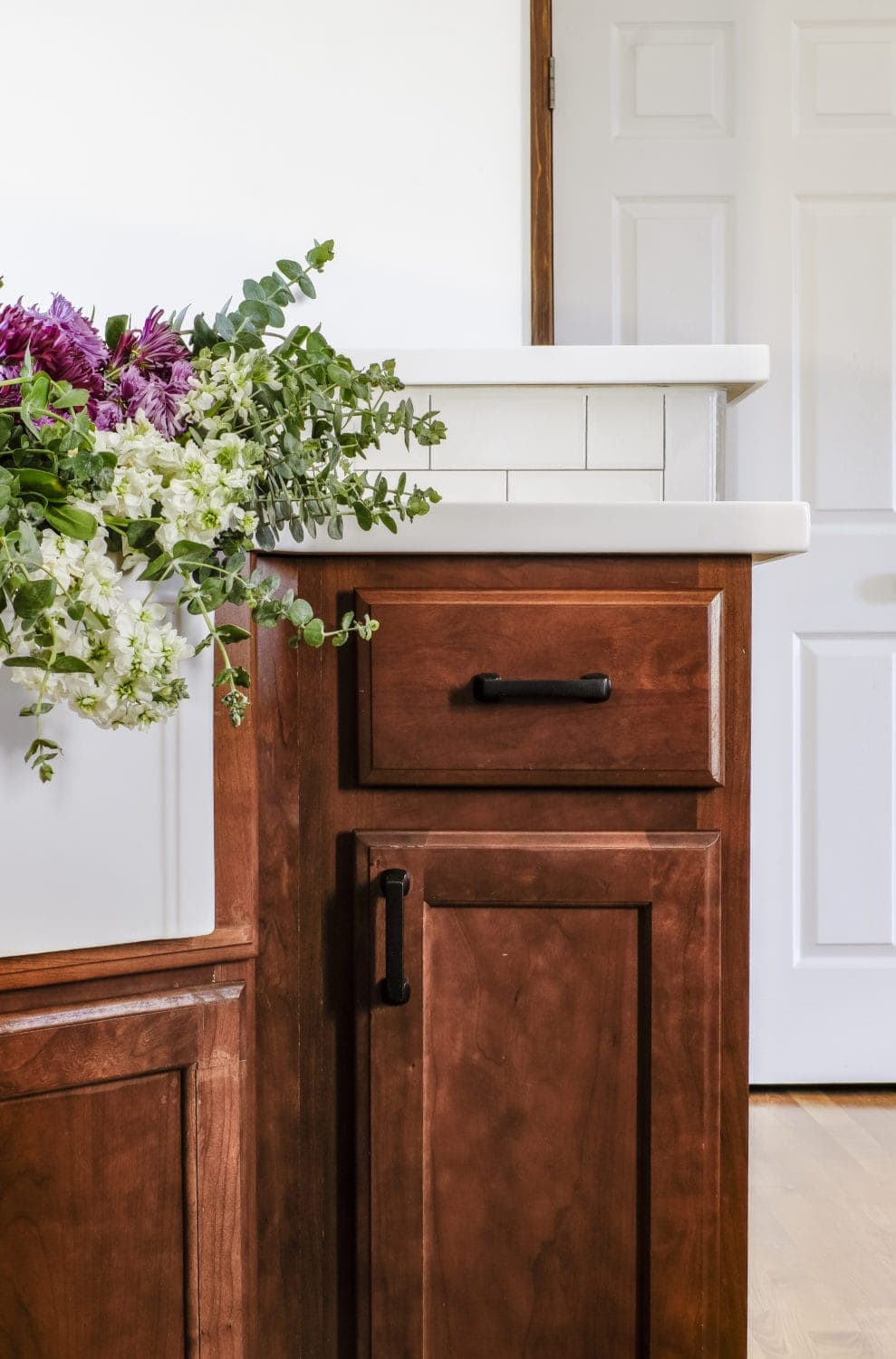 wood cabinets and white solid surface countertops with subway tile backsplash