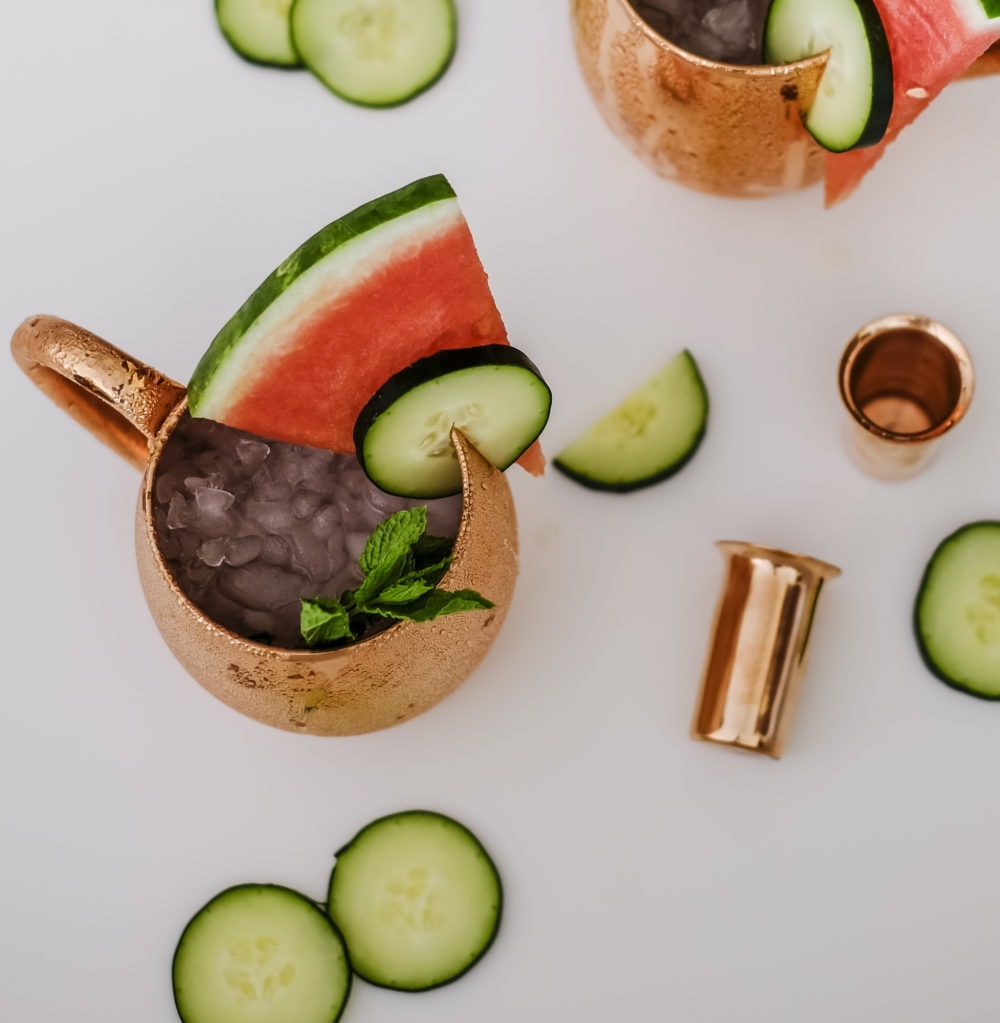 View from above a copper mug filled with cucumber watermelon moscow mule