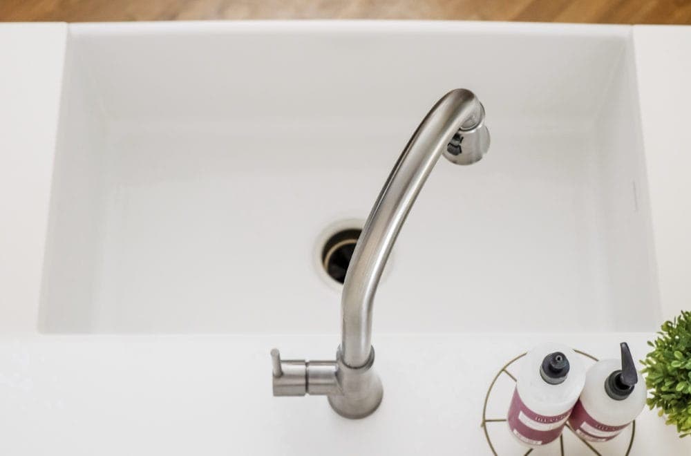 A view from behind the sink looking down on the fireclay farmhouse sink and pull down faucet