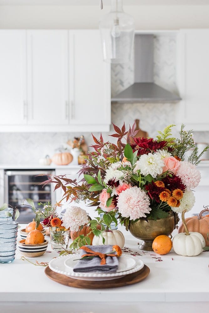 Thanksgiving table centerpieces using a large fall floral arrangement and mini pumpkins