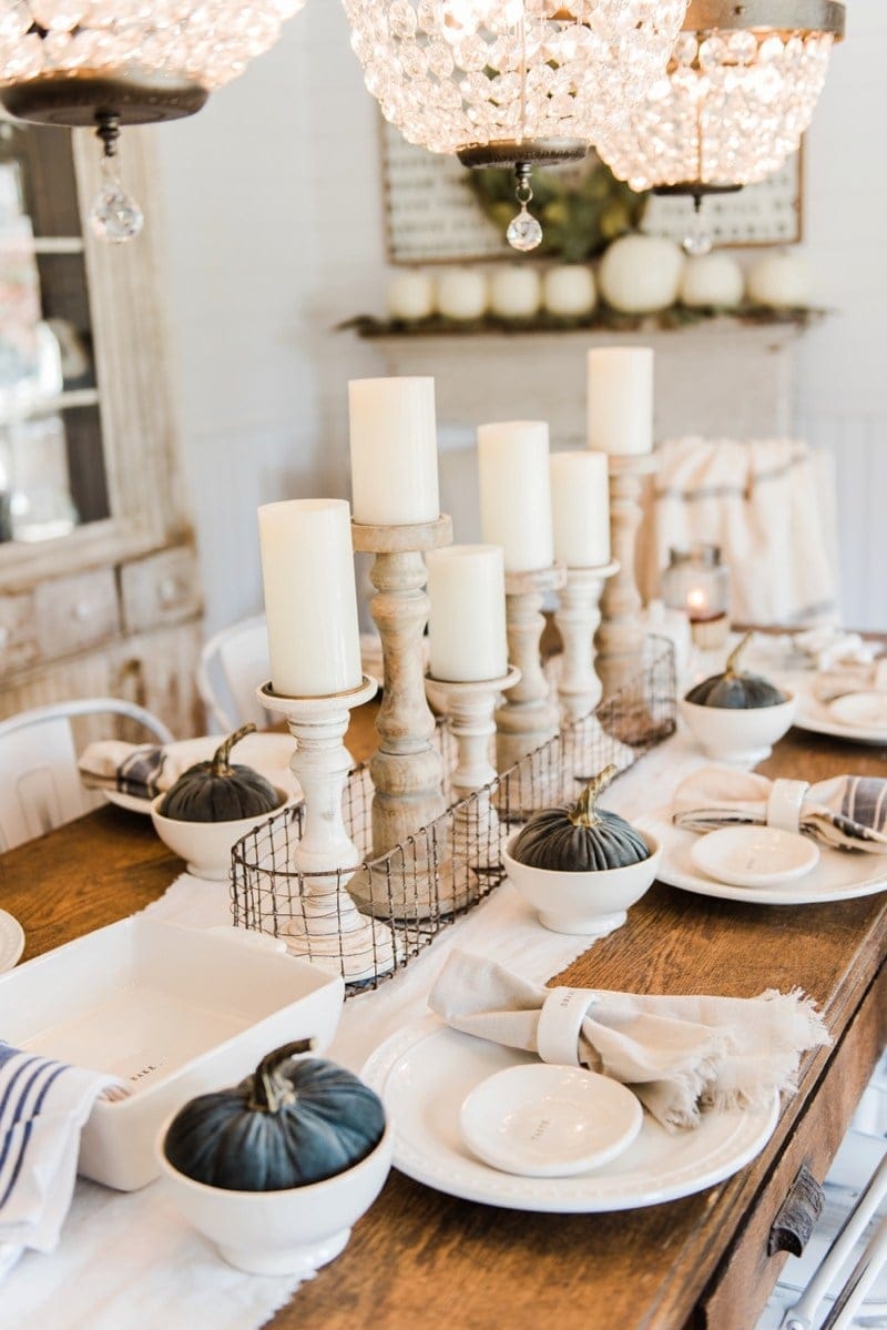 Thanksgiving table centerpieces using wood candlesticks, chunky white candles and a wire crate