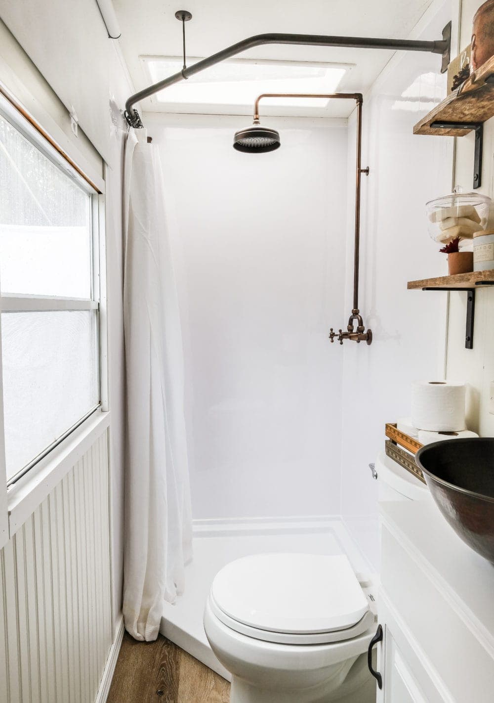 RV bathroom remodel with a bathroom shower combo, open shelving and a vessel sink