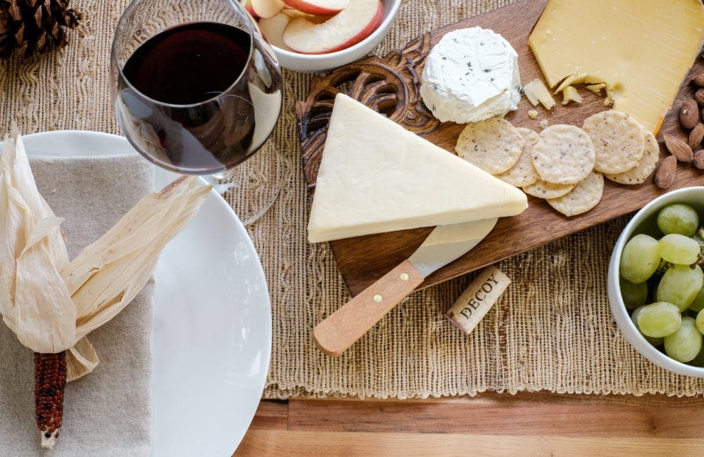 Thanksgiving table centerpiece with cheese board and wine 