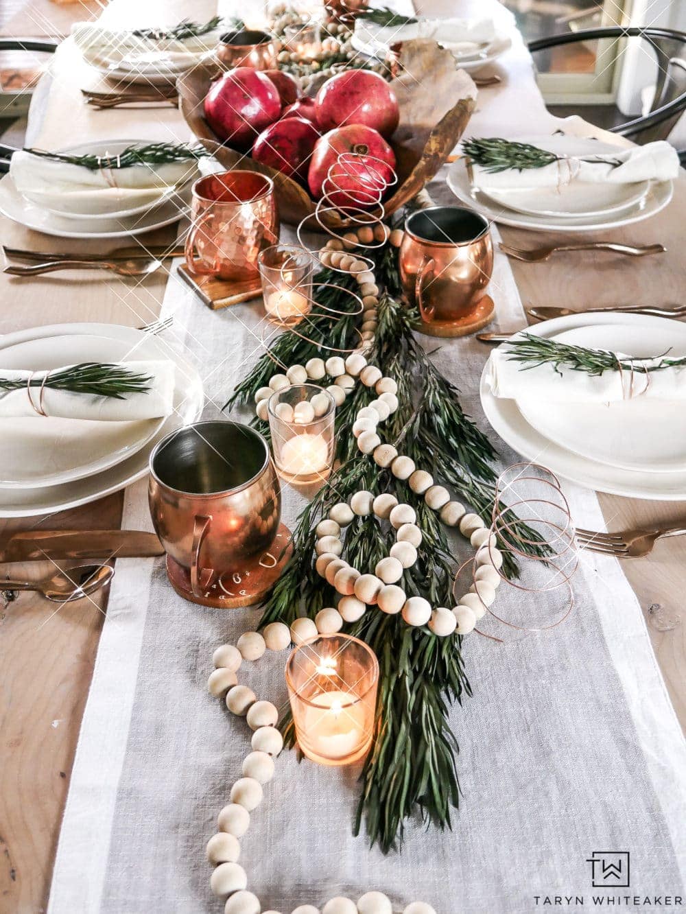 Elegant Christmas table centerpiece with wood bead garland, votive candles and copper mugs