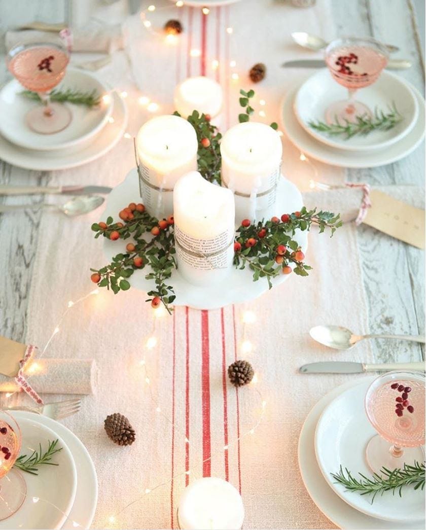 Christmas centerpiece using a red striped runner and a cakestand with candles on top