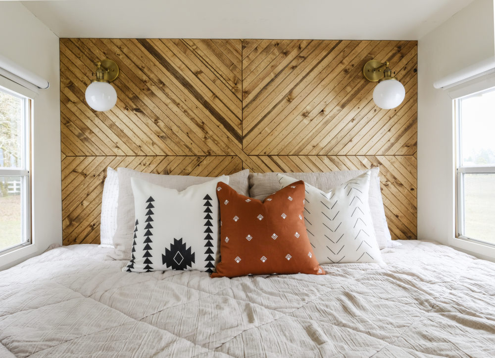 RV bed inside a popout with a wood plank accent wall