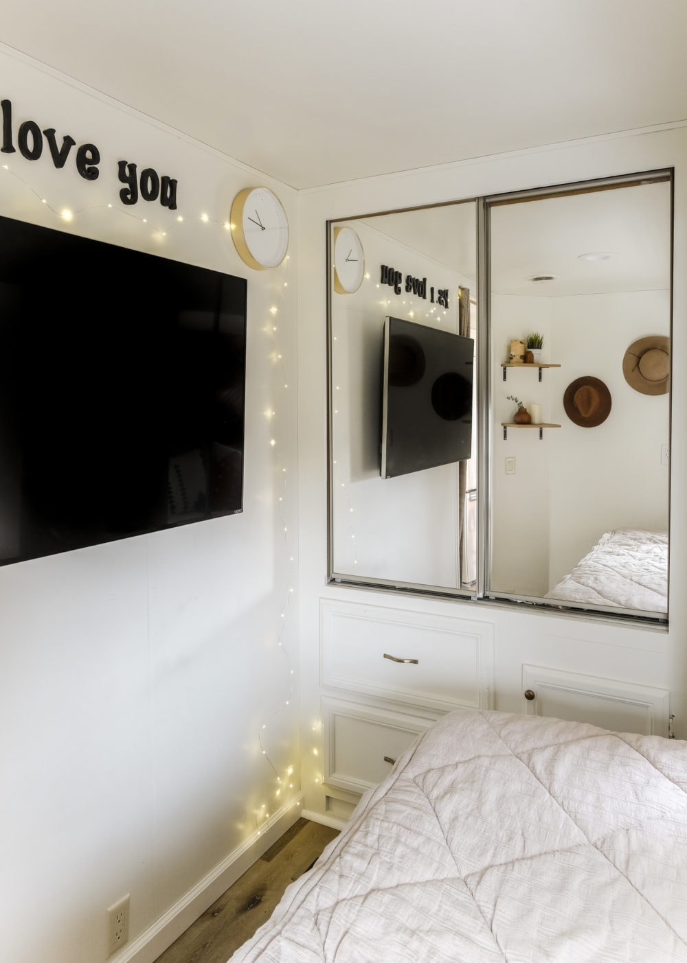 RV bedroom with wall mounted TV and mirrored door closets