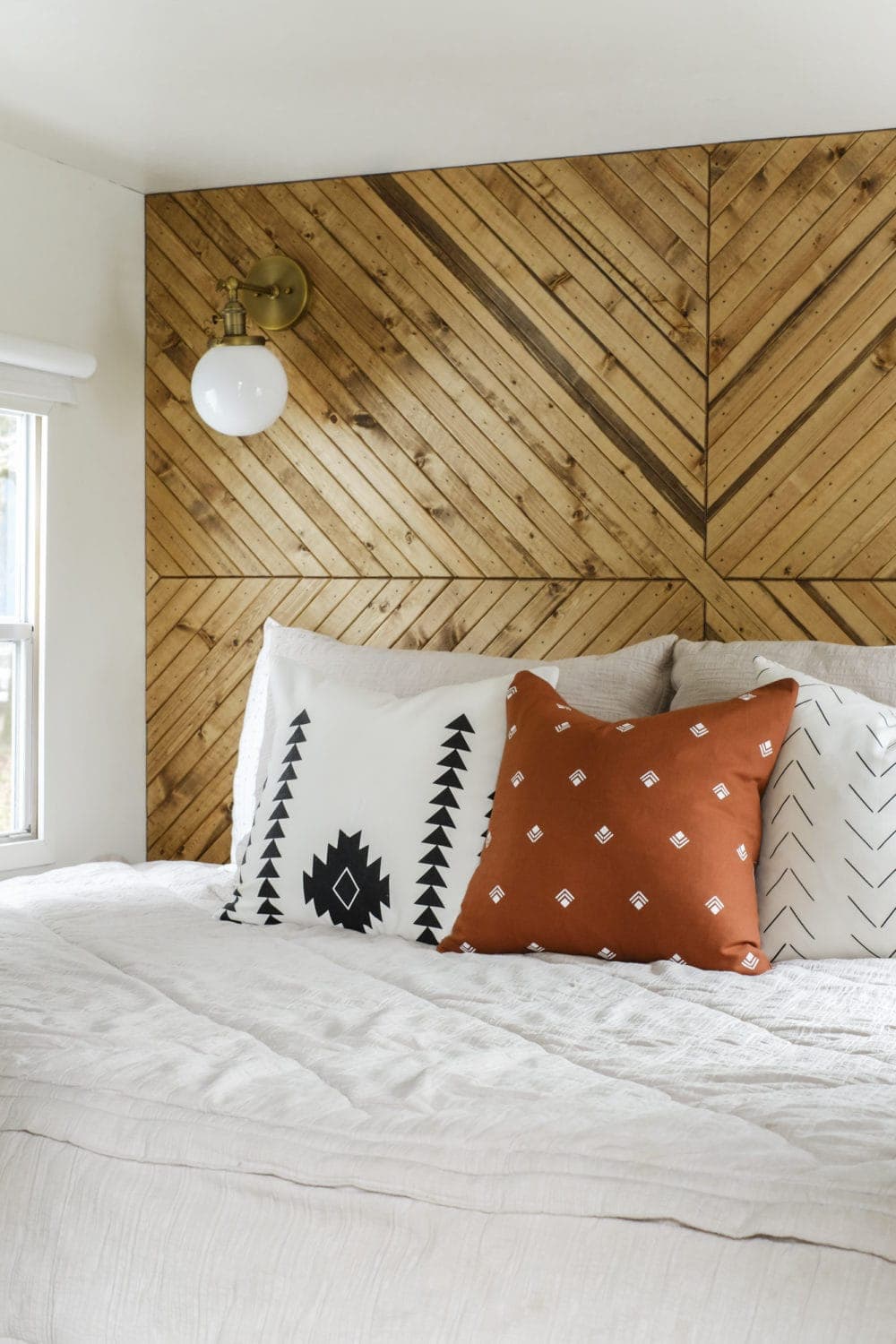 RV bedding with throw pillows and a wood accent wall headboard