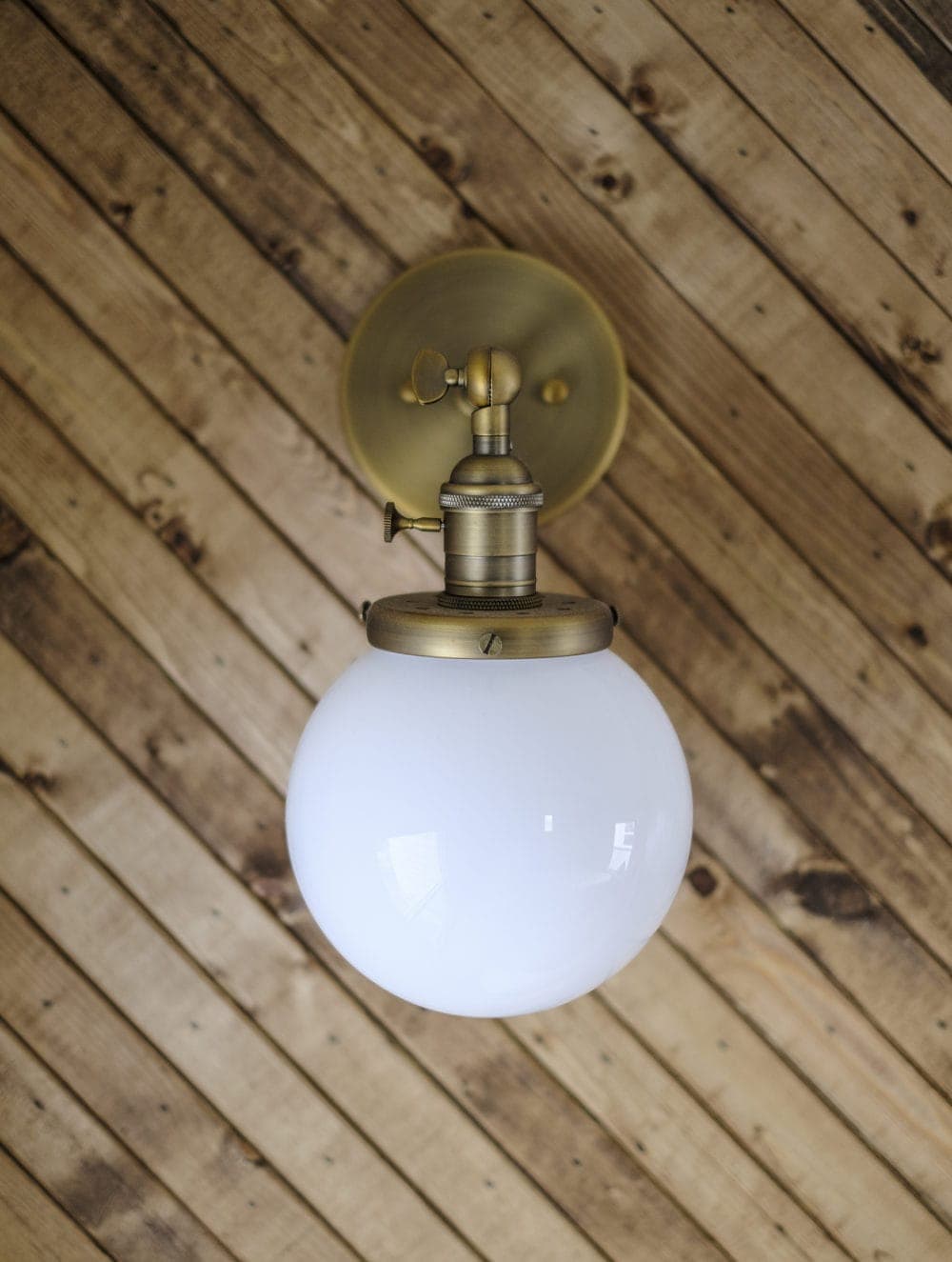 Brass wall sconce with globe light shade