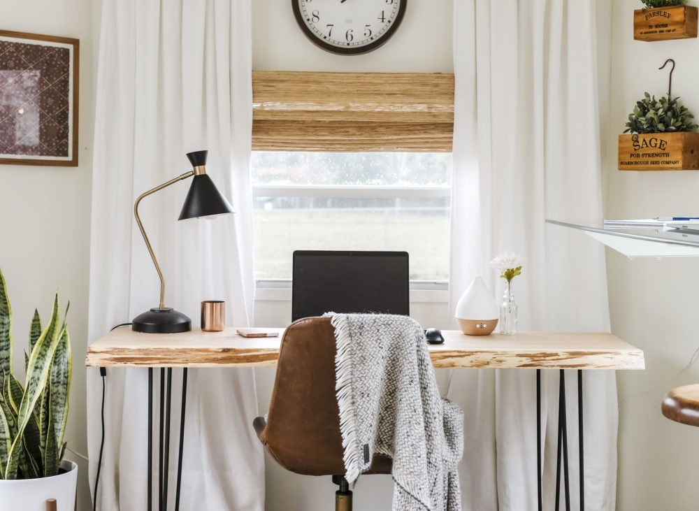 Home office inspiration with wood desk, leather chair and white curtains