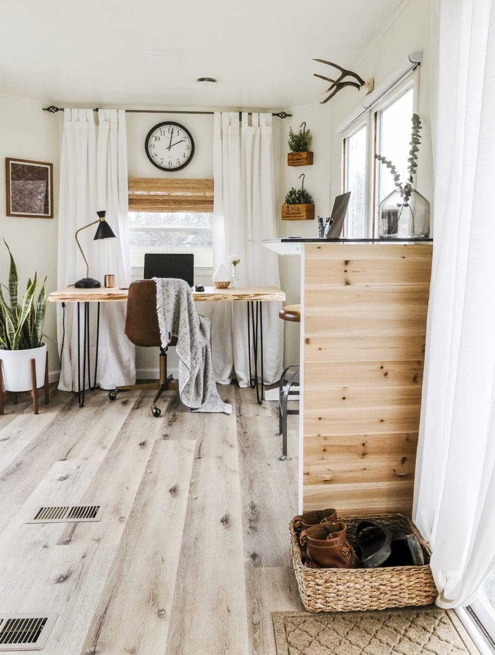 View of a home office next to an entry way with cedar planks and a shoe basket