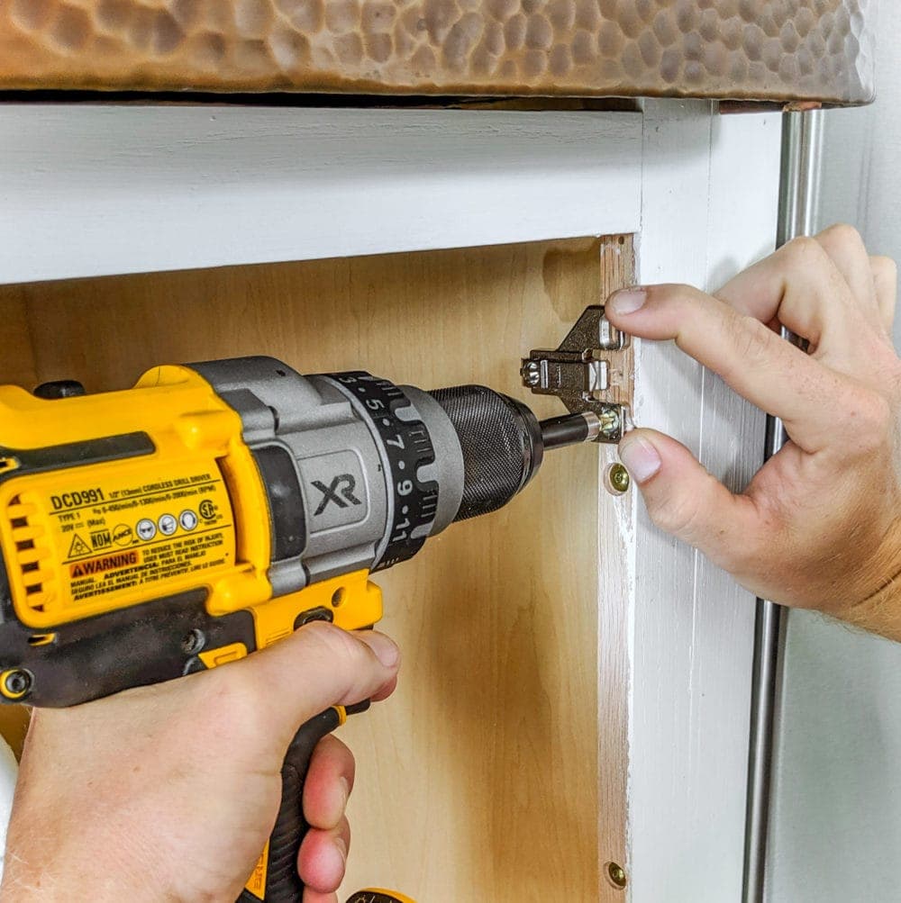 fastening a clip on hinge mounting plate to a cabinet