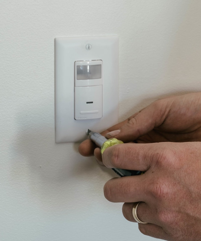 using a Klein Multi tool screwdriver to tighten a light switch cover plate