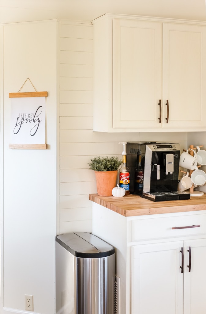 a coffee bar decorated for fall with a 'let's get spooky' printable