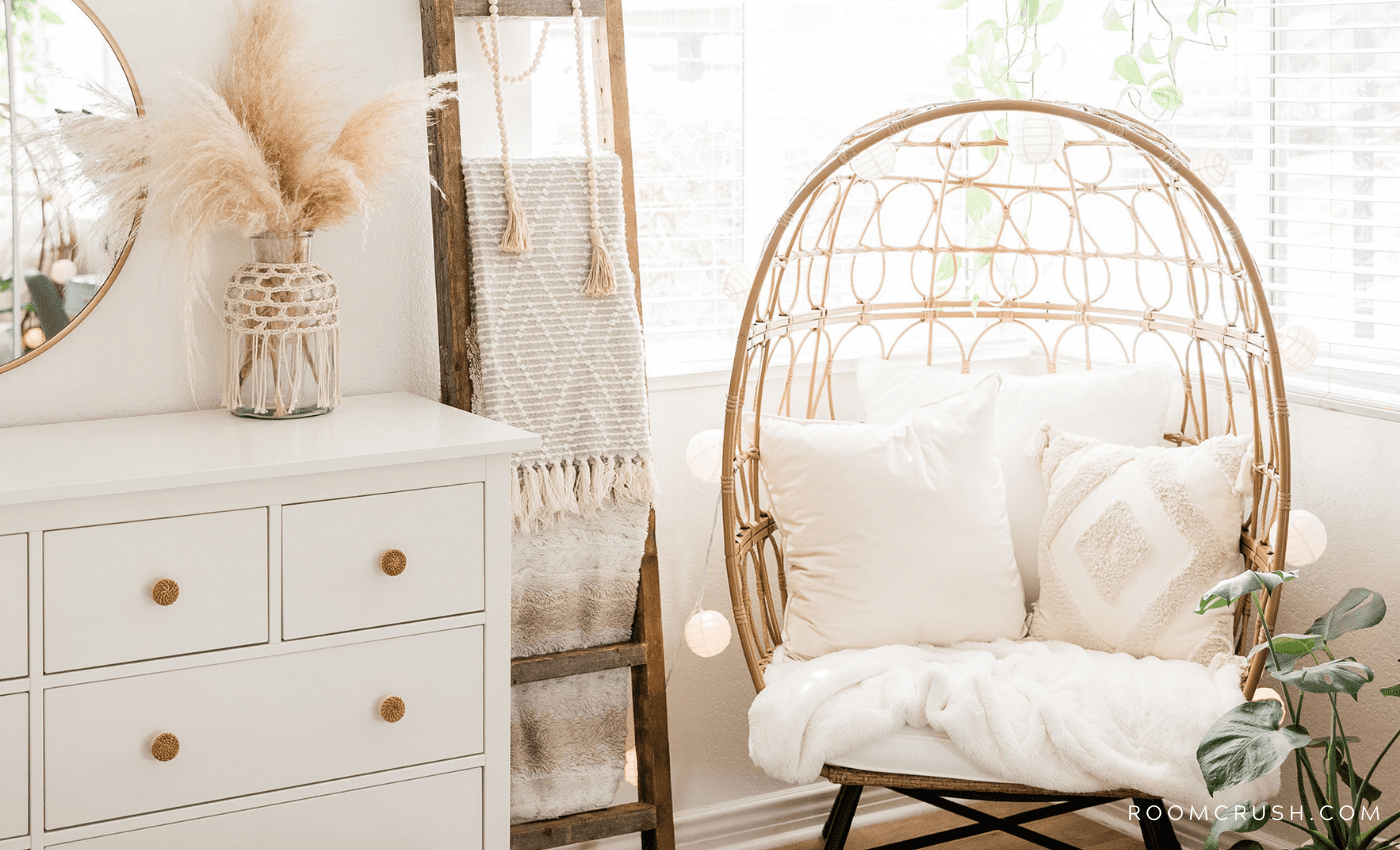 Learn How to Create a Modern Bohemian Home decor tips. Photo is of a modern bohemian home with a rattan chair in a bedroom and beige cushions.