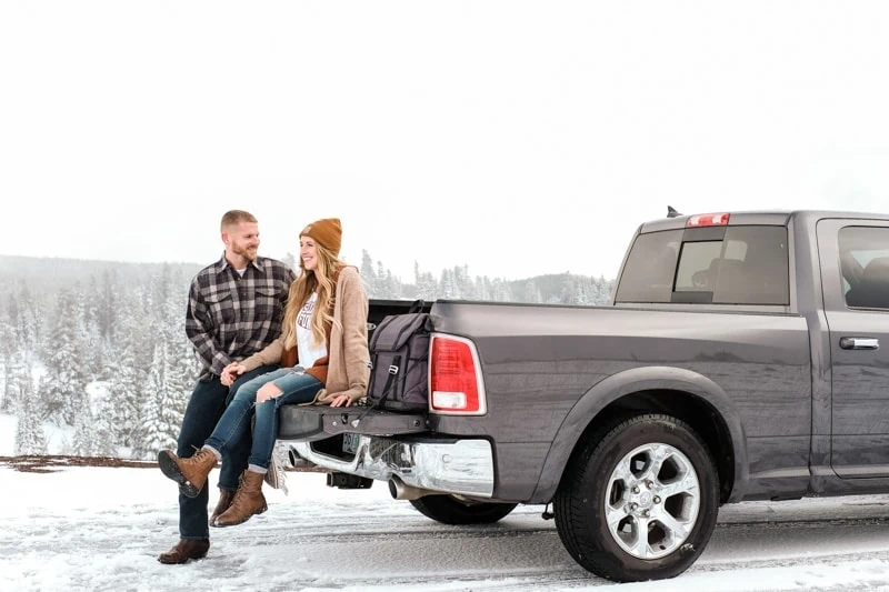 couple sits in truck enjoying holiday road trip