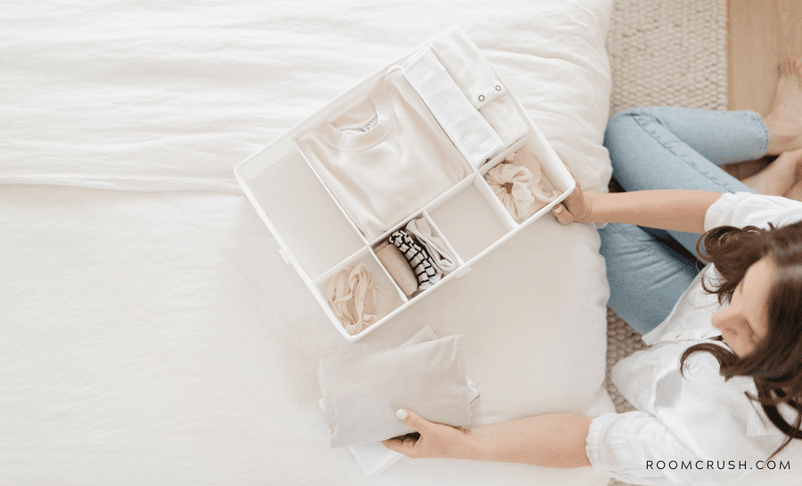 Woman showing how to organize your room by arranging shirts in a basket