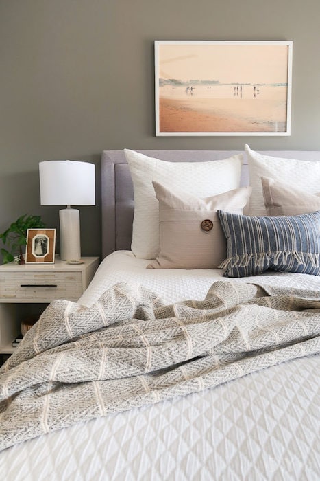 bedroom with a large painting above the headboard