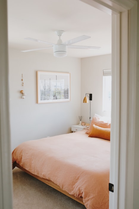 bedroom with modern looking ceiling fan above the bed