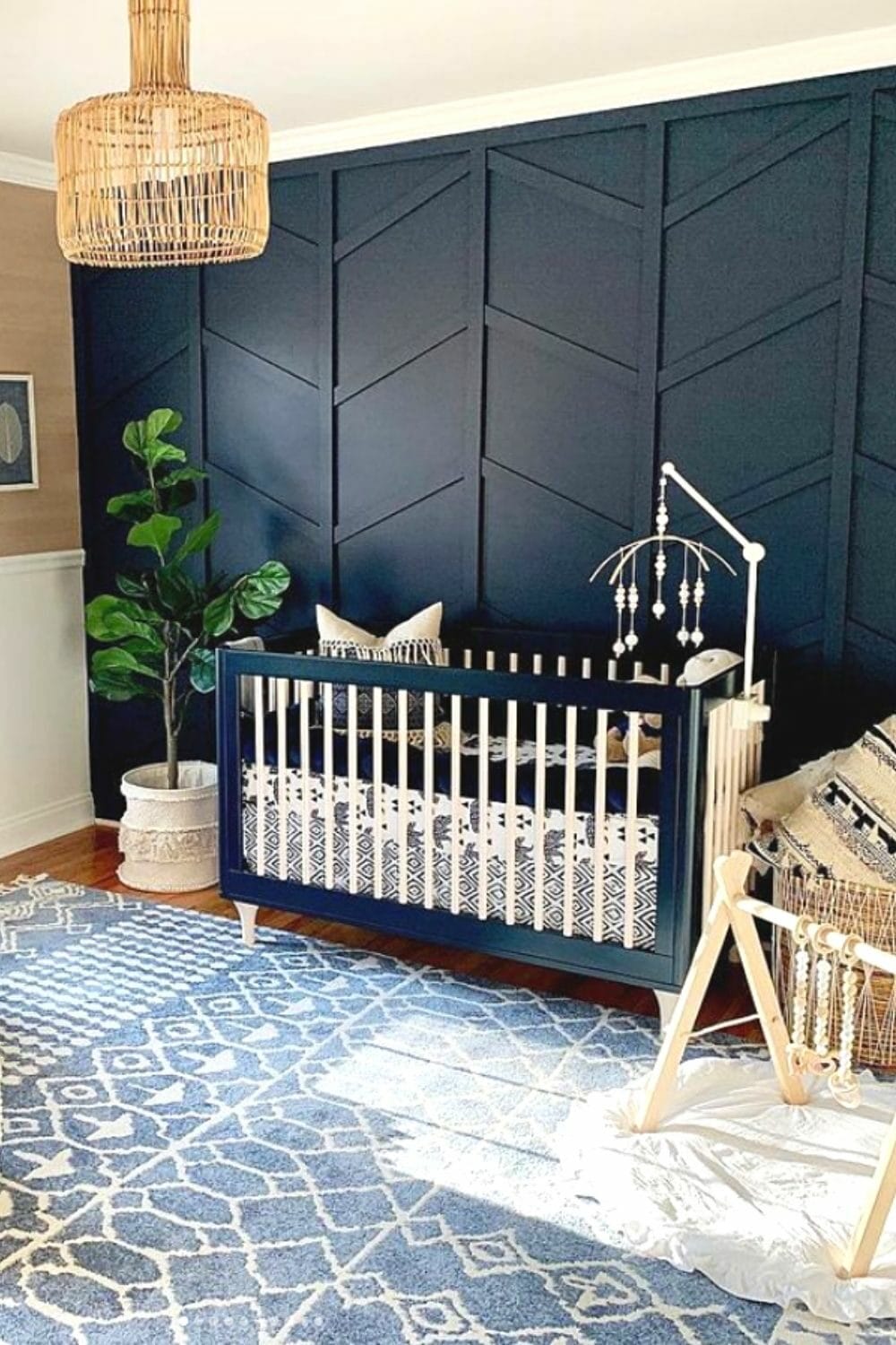 Nursery with a bold feature wall painted with Naval by Sherwin-Williams