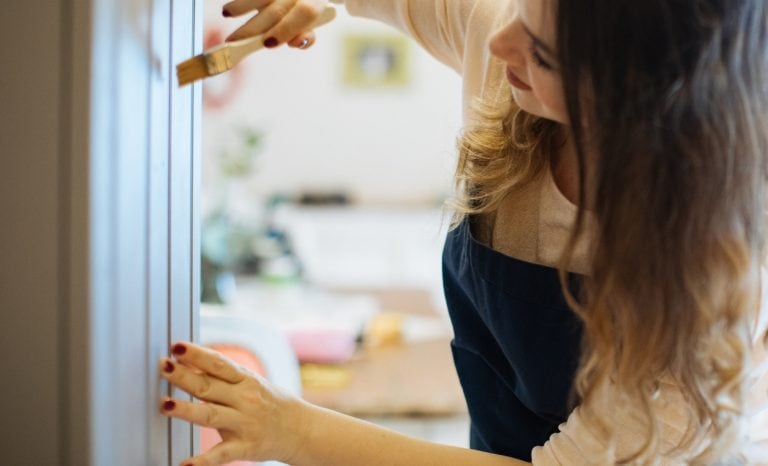 woman with paintbrush Best Kitchen Cabinet Paint Colors